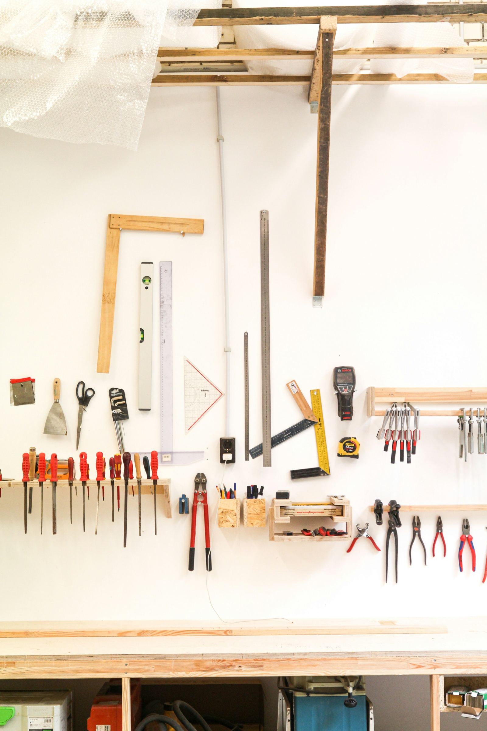 Hand tools hung and squared on a bright workshop wall