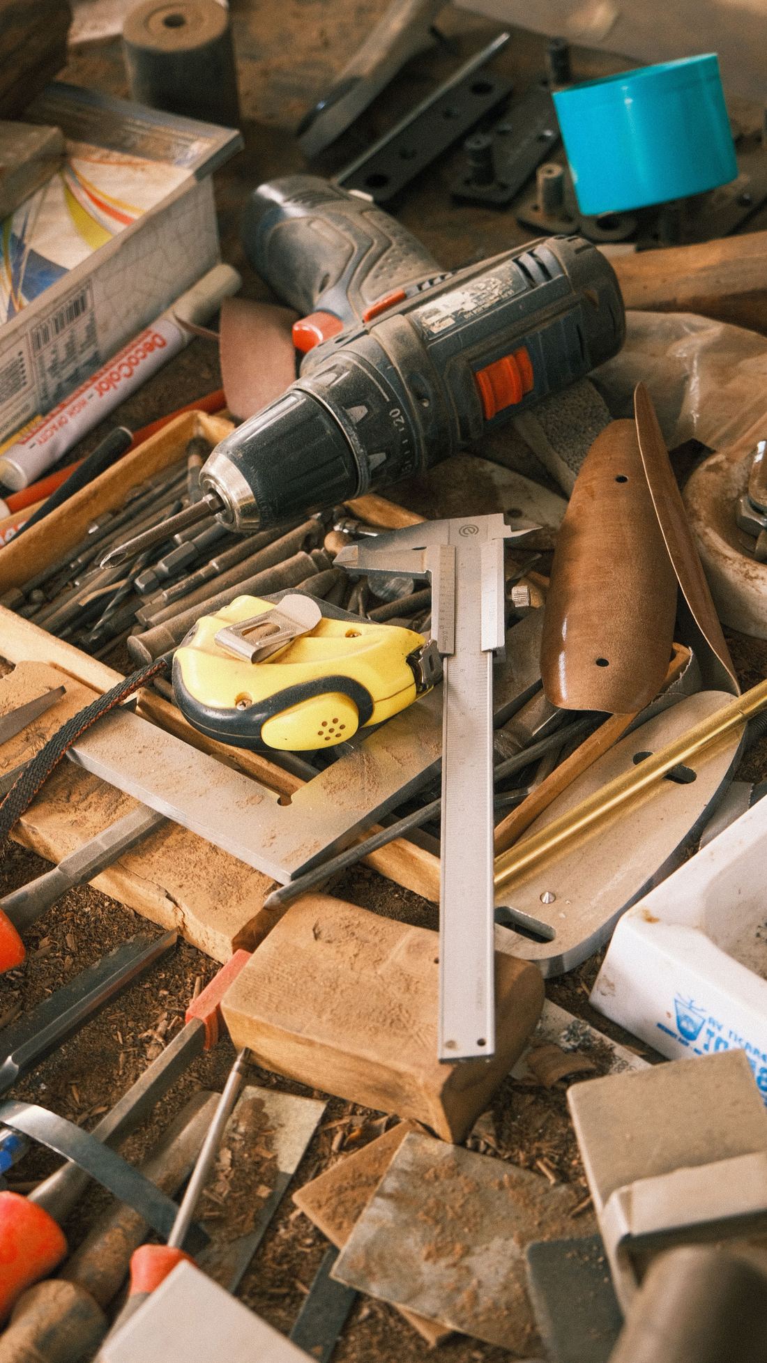 A cluttered workbench covered in scattered hand tools and sawdust